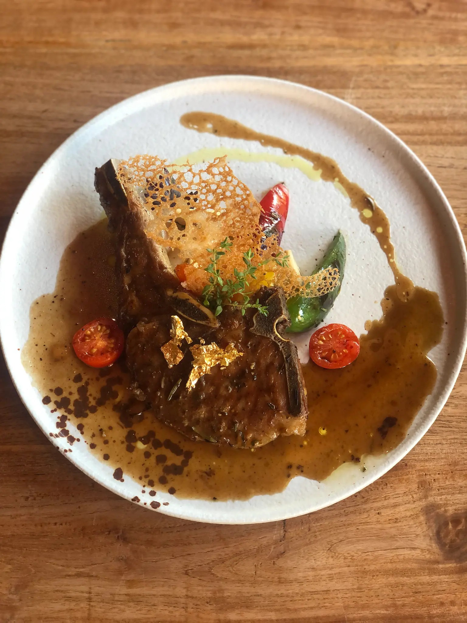 Rich sauce and a crisp garnish. A plated main is finished with a deep sauce, fresh herbs and a crisp garnish.