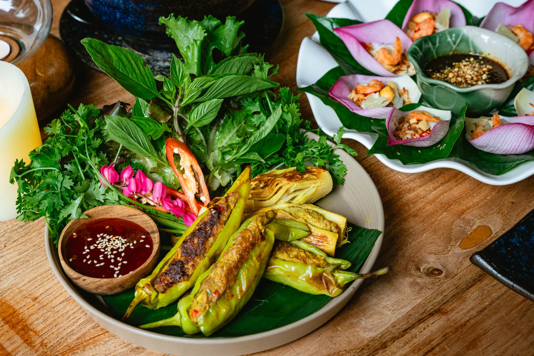 Grilled vegetables and floral-plated bites. Grilled green vegetables with herbs and dip sit beside small bites arranged in pink flower petals. Photographed at Wiang Neua Café & Restaurant in Chiang Saen, Chiang Rai.