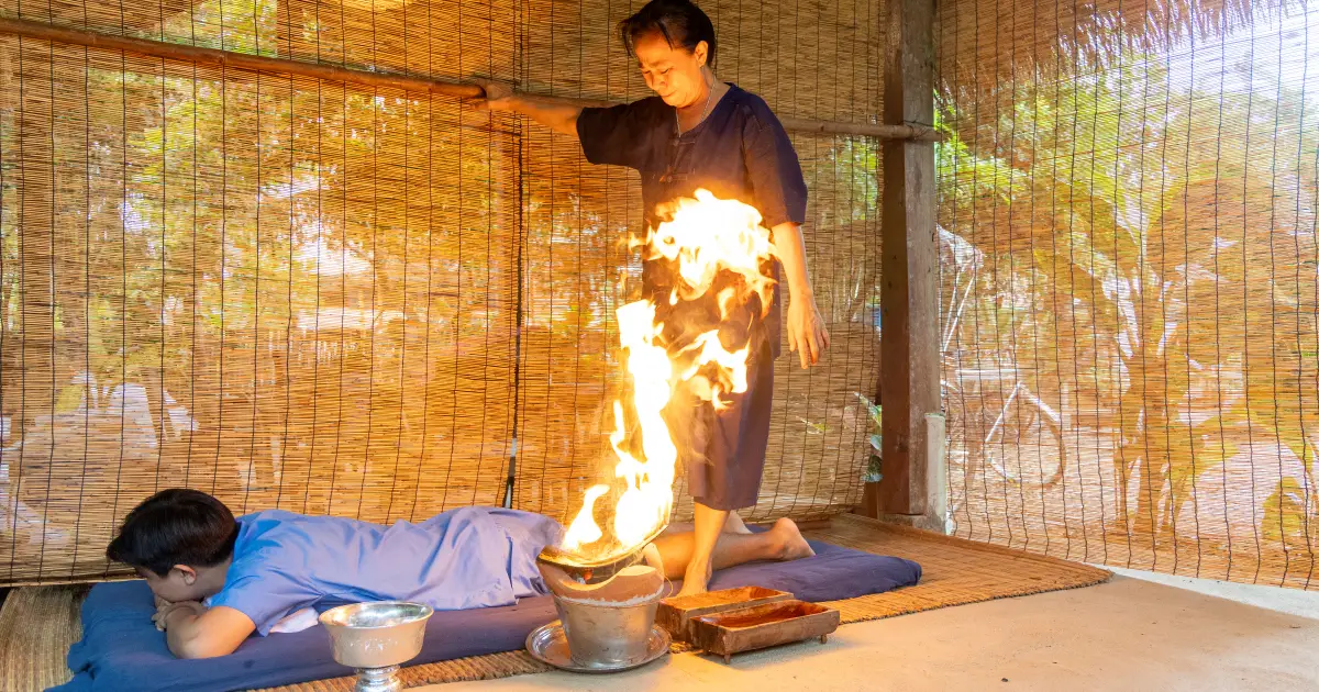 A person receiving a fire-based traditional wellbeing practice in a local setting